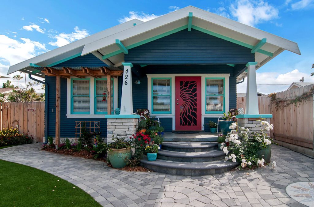 Blue house with red door and steps.