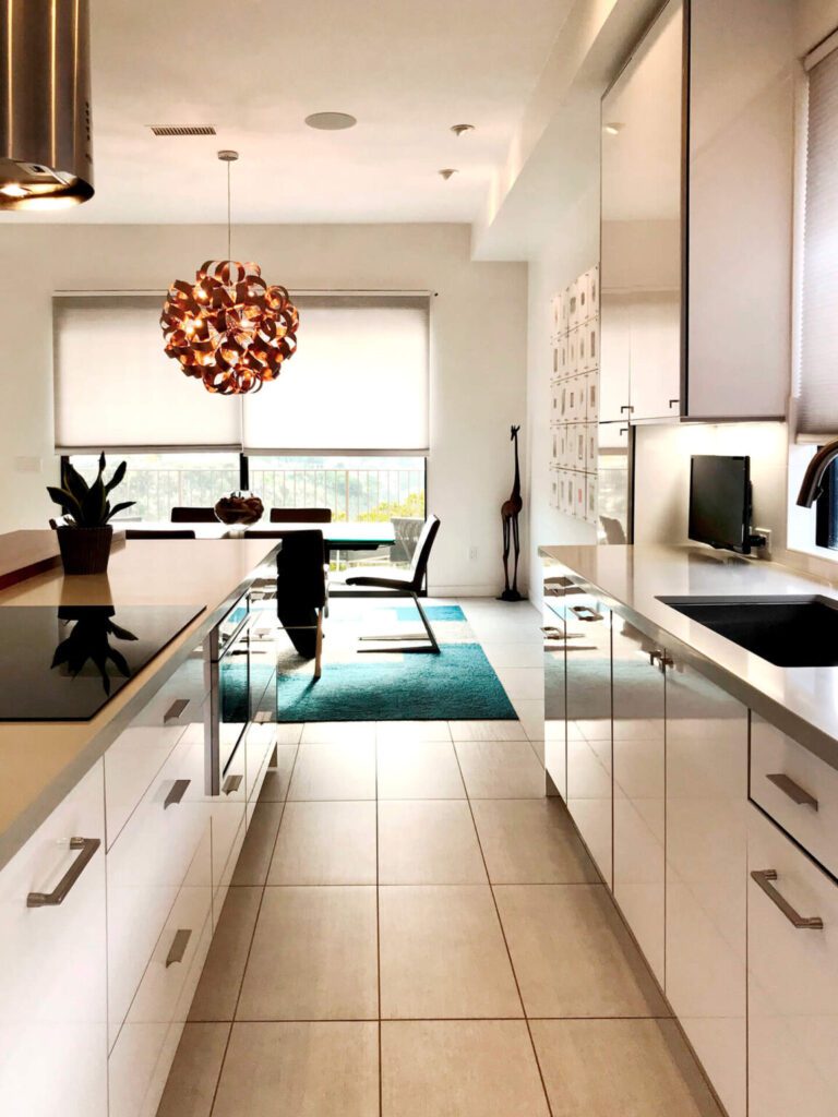 Modern kitchen with white cabinets and a teal rug.