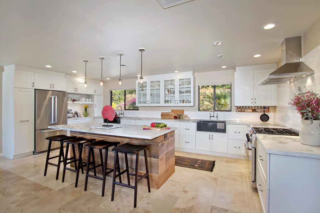 White kitchen with island and bar stools.